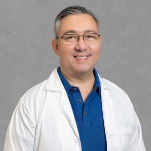 Joel Lippe, primary care provider at Optima Medical in Tucson, Arizona, wearing a blue shirt and white lab coat.