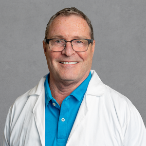 Terence D. Williams, healthcare provider at Optima Medical in Surprise, Arizona, smiling in a white coat and blue shirt.
