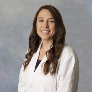 Raven Taylor, primary care provider at Optima Medical in Queen Creek, Arizona, wearing a white coat and smiling.