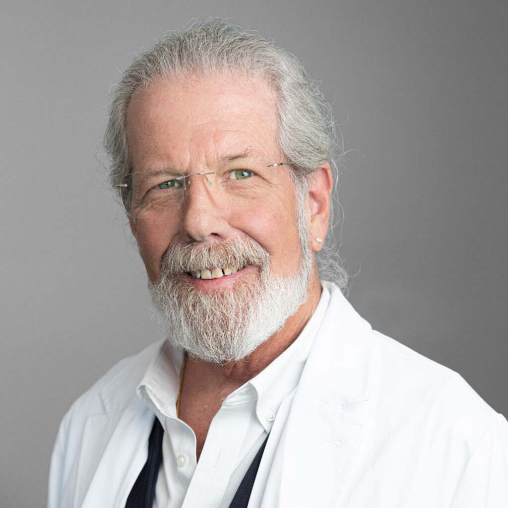 Dr. Craig Levy, primary care physician at Optima Medical in South Lake Havasu City, Arizona, smiling in a white coat and glasses.