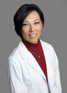 Blondie Miley, healthcare provider at Optima Medical in South Lake Havasu City, Arizona, wearing a white coat and red top.