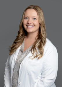 Candace Nysted, medical provider at Optima Medical in South Lake Havasu City, Arizona, smiling in a professional portrait wearing a white coat.