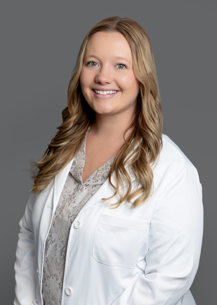 Candace Nysted, medical provider at Optima Medical in South Lake Havasu City, Arizona, smiling in a professional portrait wearing a white coat.