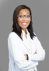 Julia Chavez, medical provider at Optima Medical in Tucson, Arizona, smiling in glasses and a white coat.