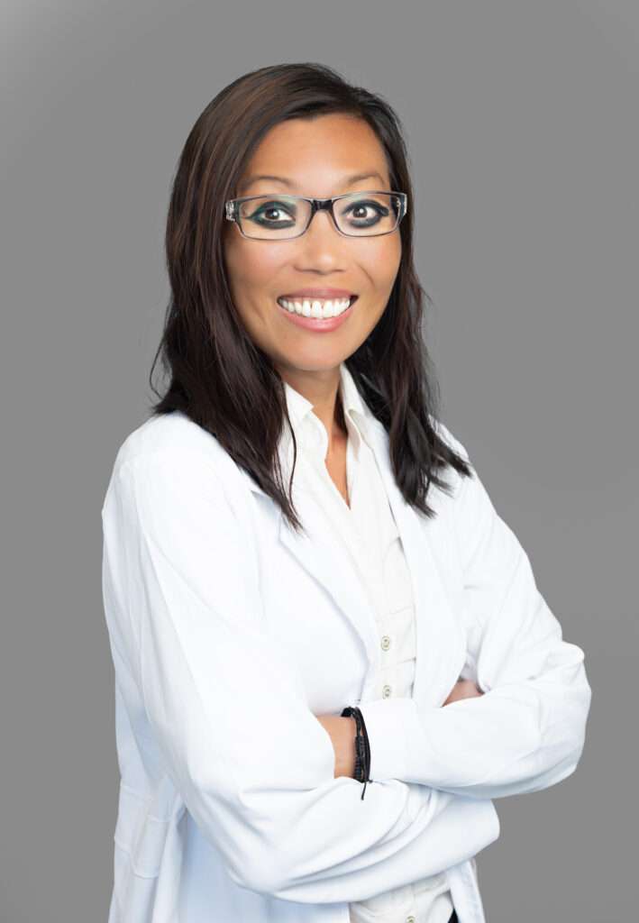Julia Chavez, medical provider at Optima Medical in Tucson, Arizona, smiling in glasses and a white coat.