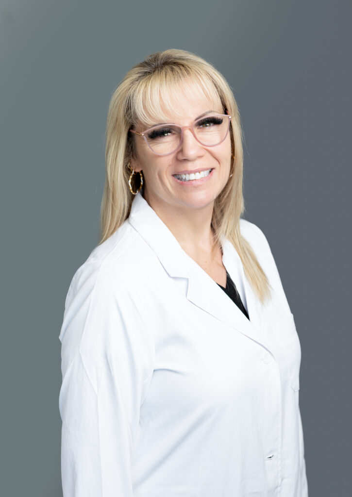 Nancy Schaffner, medical provider at Optima Medical in South Bullhead City, Arizona, wearing glasses and white coat in professional headshot.