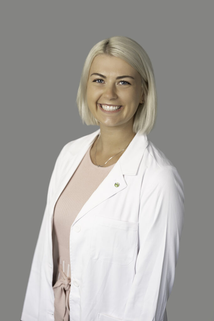 Natasha Swedlund-Poeppel, medical provider at Optima Medical in Surprise, Arizona, smiling in a white coat and pink top.